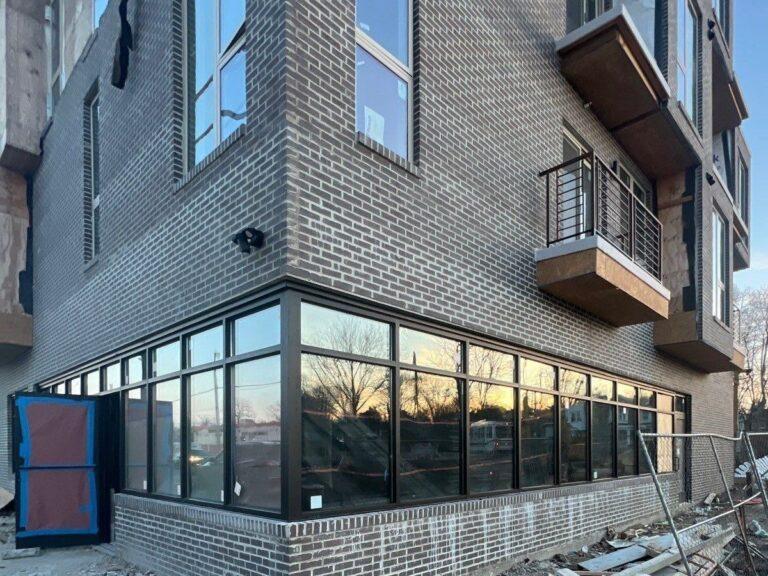 Ribbon of corner storefront windows on a new mixed-use building