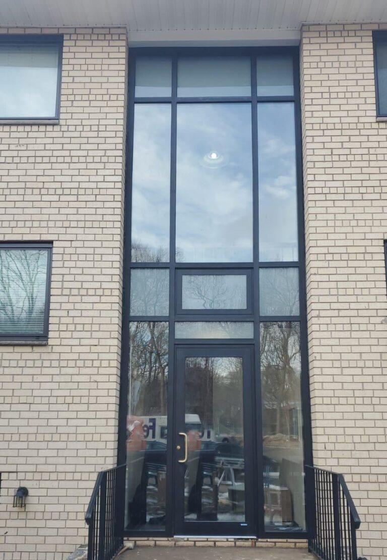 Two-story aluminum curtain wall entrance on a brick building