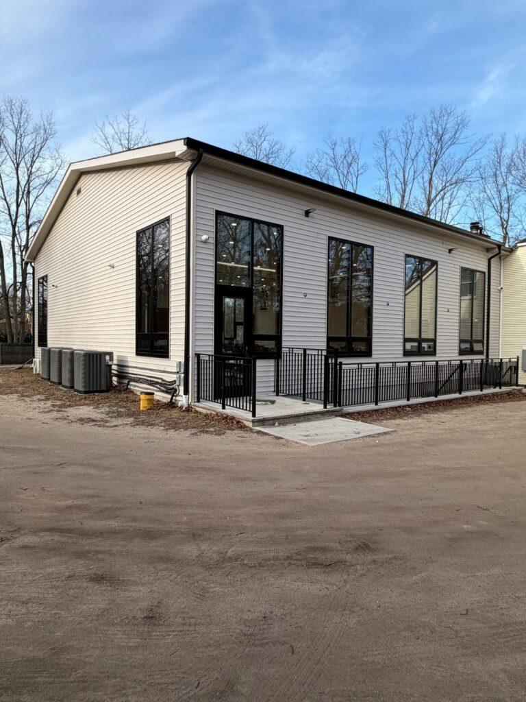 Tall black storefront windows and entry on a commercial building by Pexic Windows