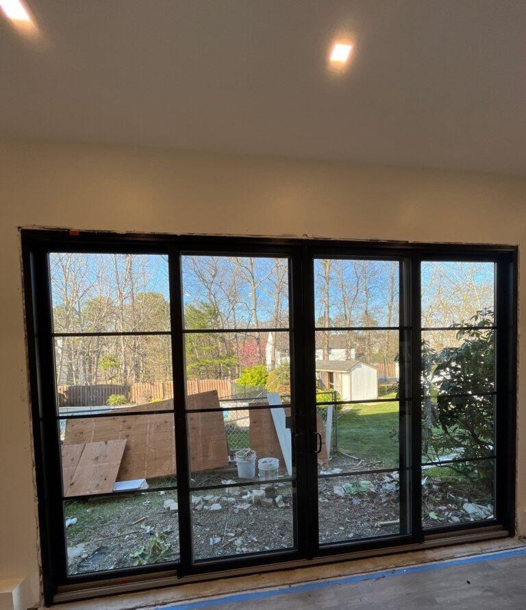 Black multi-panel patio door with grilles, interior view by Pexic Windows