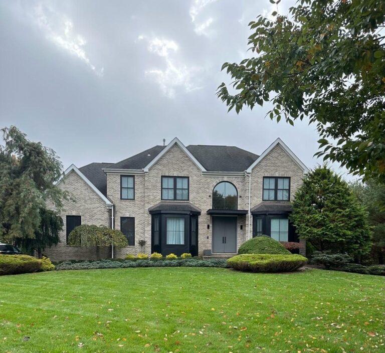 Brick colonial home with new black windows and bay windows by Pexic Windows