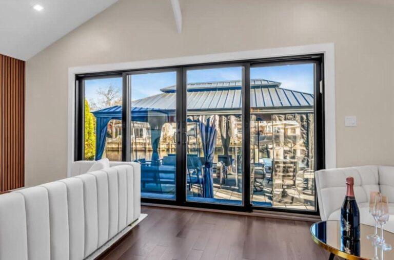 Large black sliding glass doors facing the water by Pexic Windows